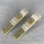 گل سر با روبان گروگن سفید و نگین طلایی روی زمینه خاکستری