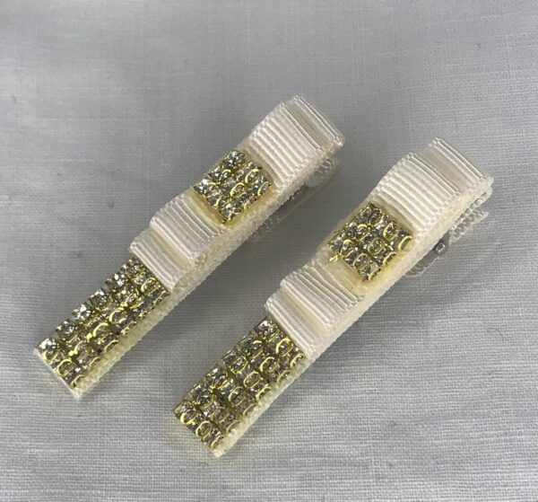 گل سر با روبان گروگن سفید و نگین طلایی روی زمینه خاکستری