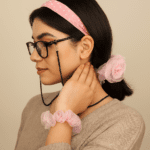 اکسسوری های دست‌دوز شامل کش مو حریر، تل سر پارچه ای و بند عینک مهره ای روی بدن مدل زن